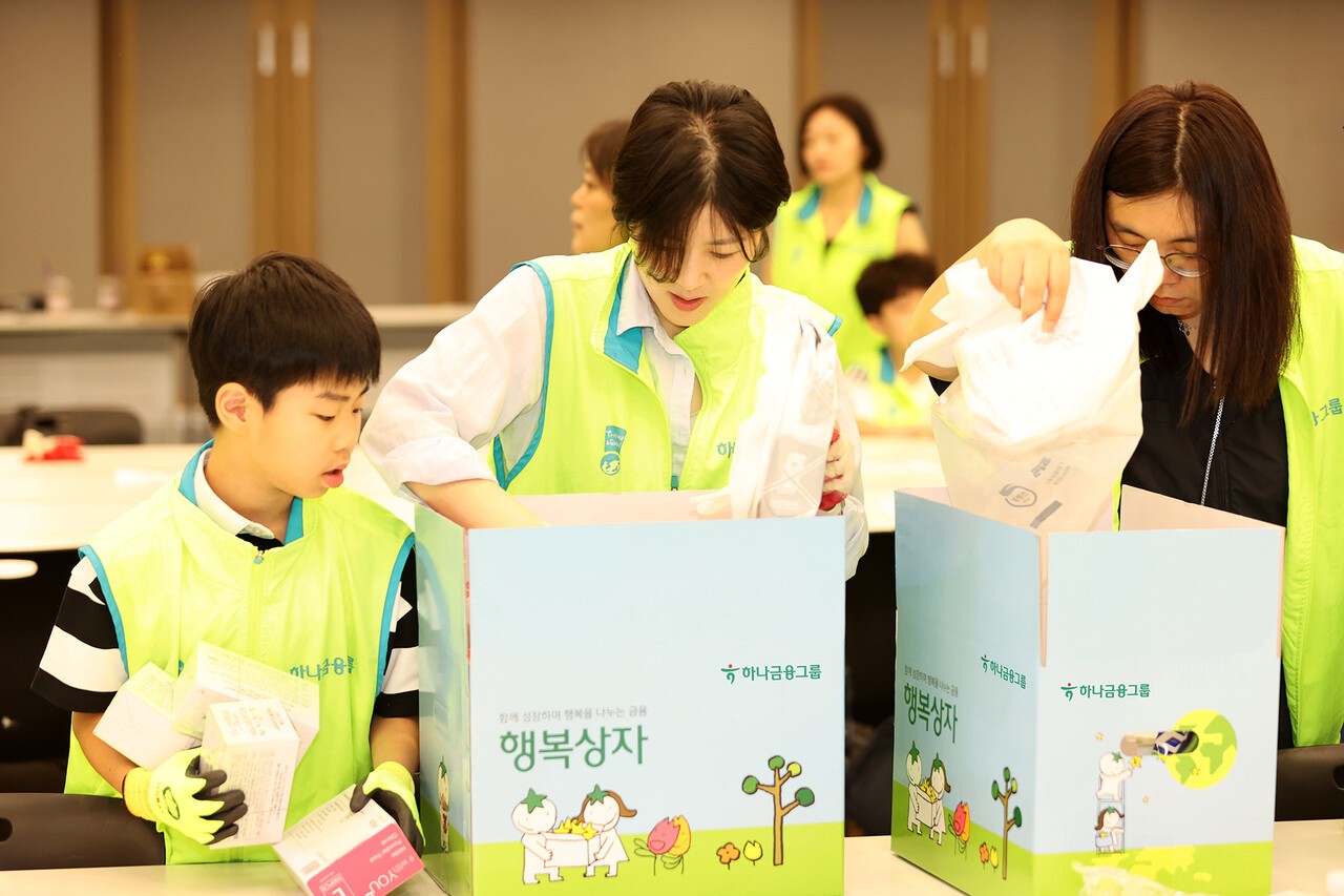 봉사활동에 참석한 하나금융그룹 임직원 및 가족들이 지역 소상공인들에게 전달할 행복상자를 만들고 있다.